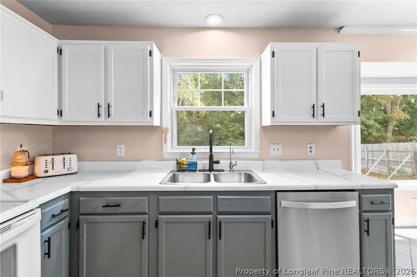 a kitchen with stainless steel appliances granite countertop a sink a stove and cabinets