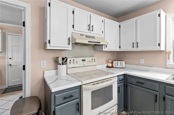 a kitchen with granite countertop white cabinets and white appliances