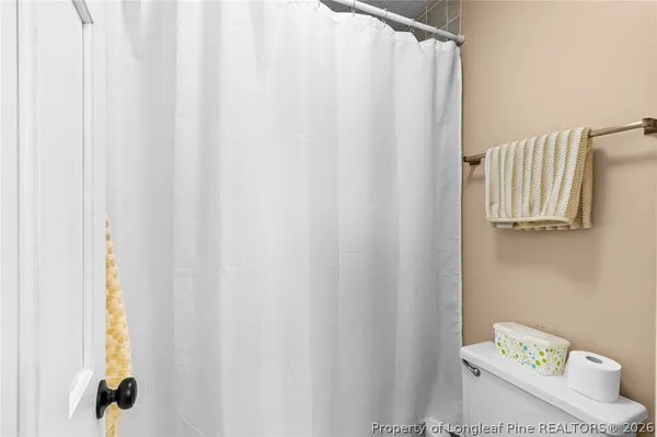 a bathroom with a shower curtain and a window
