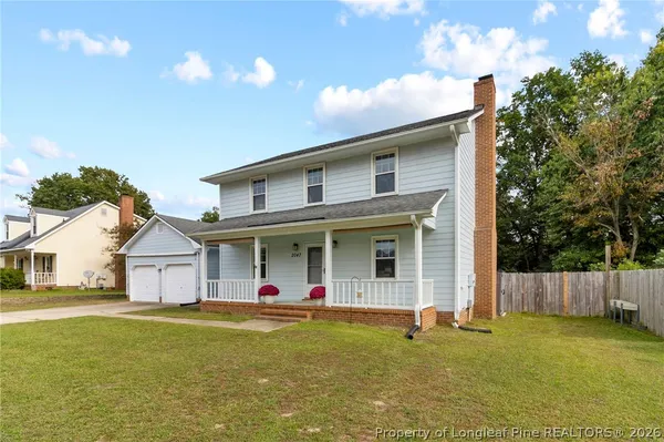 a view of a white house with a swimming pool and a yard
