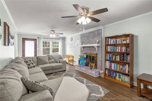 a living room with furniture a bookshelf and a large window