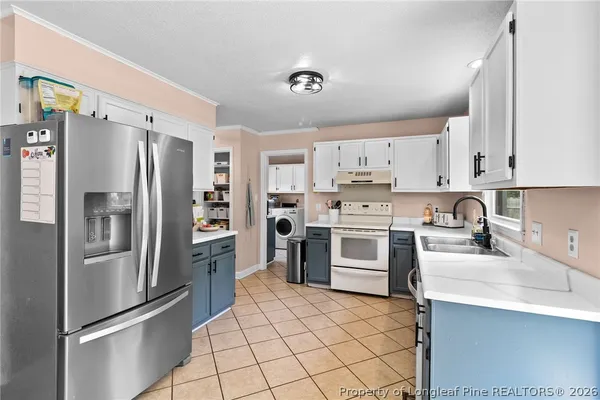 a kitchen with granite countertop a refrigerator stove and sink