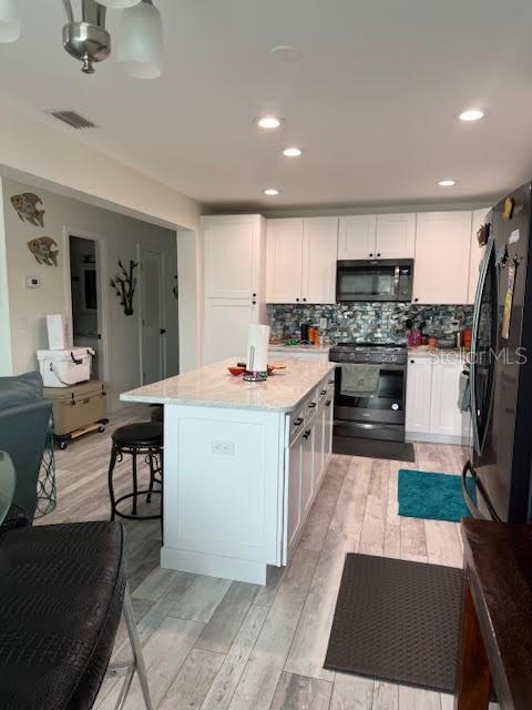 30 Southeast Valare Lane, Unit 102B Crystal River, FL 34429 - Photo 31 of 47 a kitchen with stainless steel appliances a stove a sink dishwasher a refrigerator and a dining table with wooden floor