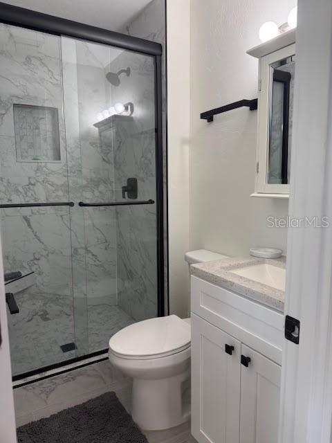 30 Southeast Valare Lane, Unit 102B Crystal River, FL 34429 - Photo 40 of 47 a bathroom with a granite countertop shower a toilet and sink