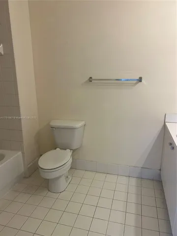 a white toilet sitting next to a shower