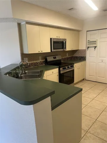 a kitchen with a sink stove and microwave