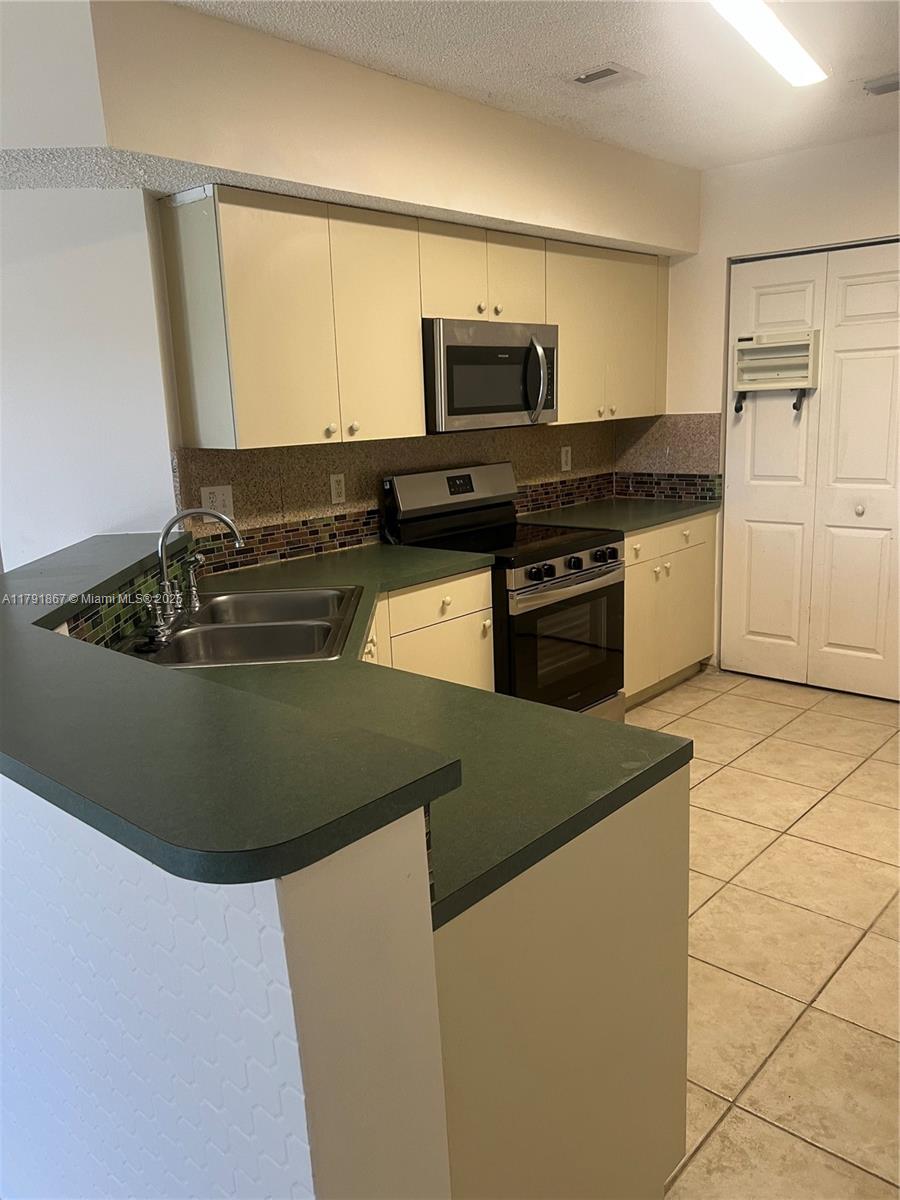 5357 Southwest 125th Avenue Miramar, FL 33027 - Photo 9 of 39 a kitchen with a sink stove and microwave