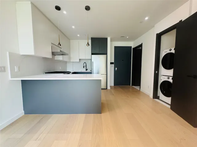 a kitchen with stainless steel appliances a sink a stove a refrigerator cabinets and a refrigerator