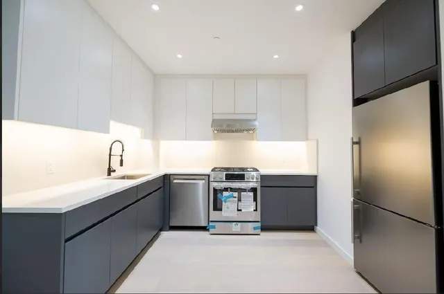 a kitchen with stainless steel appliances granite countertop a refrigerator and a sink