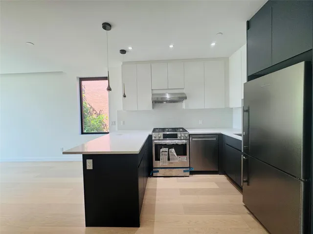 a kitchen with stainless steel appliances a stove a refrigerator and a cabinets