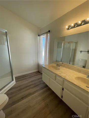 a spacious bathroom with a granite countertop sink a toilet a mirror and vanity