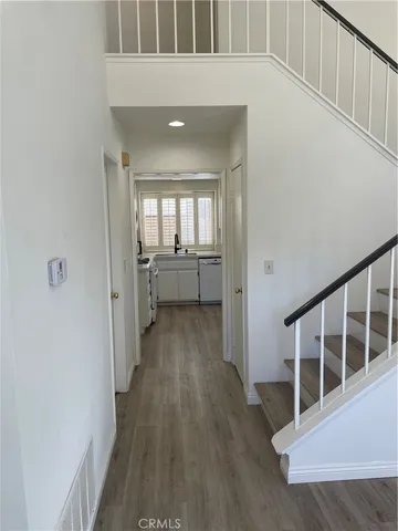 a view of a hallway with wooden floor and staircase
