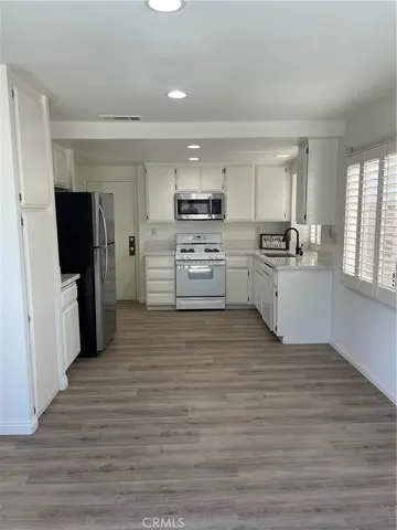 a kitchen with stainless steel appliances a refrigerator sink and stove