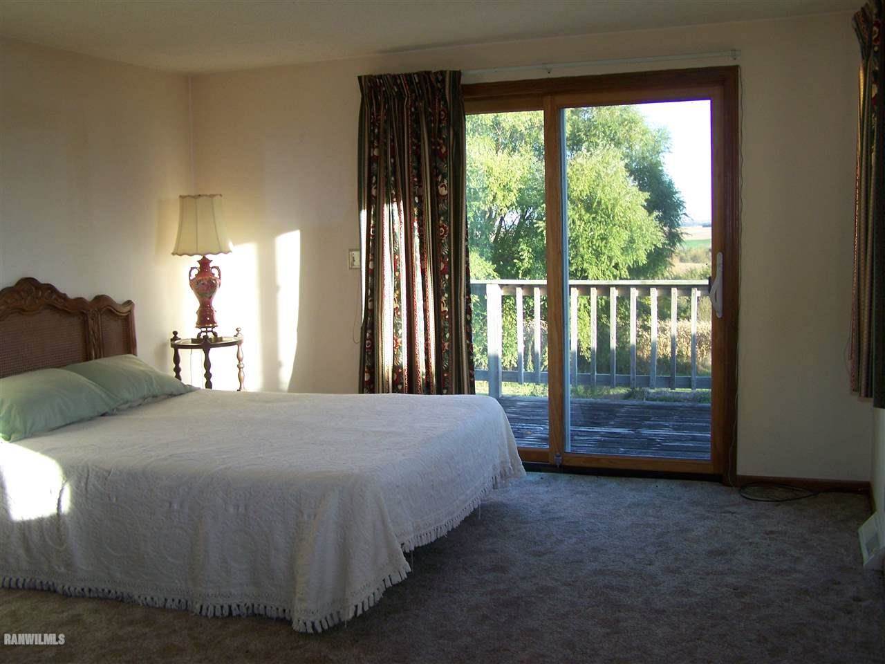 9833 Becker Road Savanna, IL 61074 - Photo 14 of 25 a bedroom with a large bed and a large window