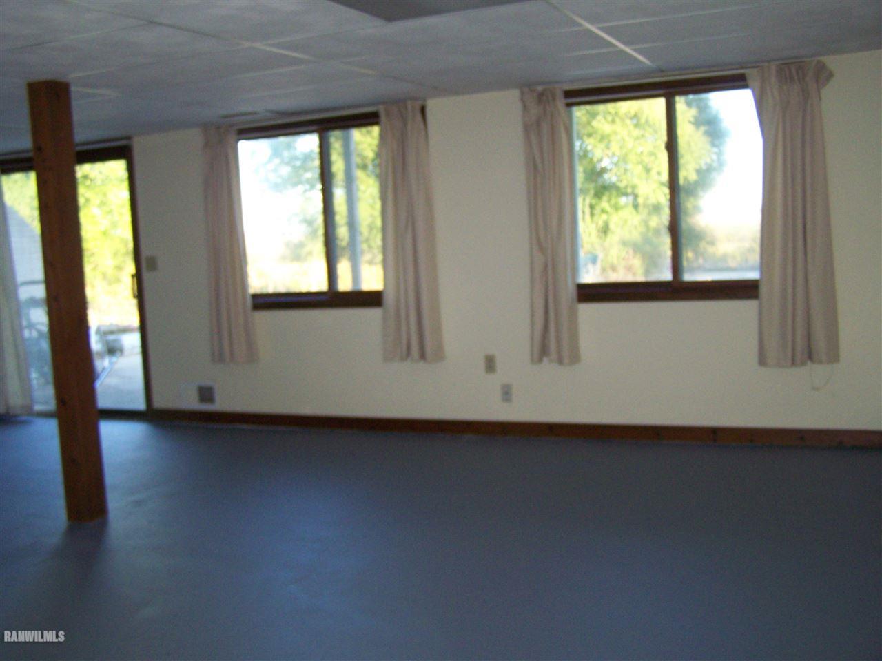 9833 Becker Road Savanna, IL 61074 - Photo 18 of 25 a view of an empty room with wooden floor and a window