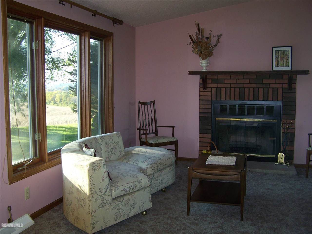 9833 Becker Road Savanna, IL 61074 - Photo 10 of 25 a living room with furniture a window and a fireplace