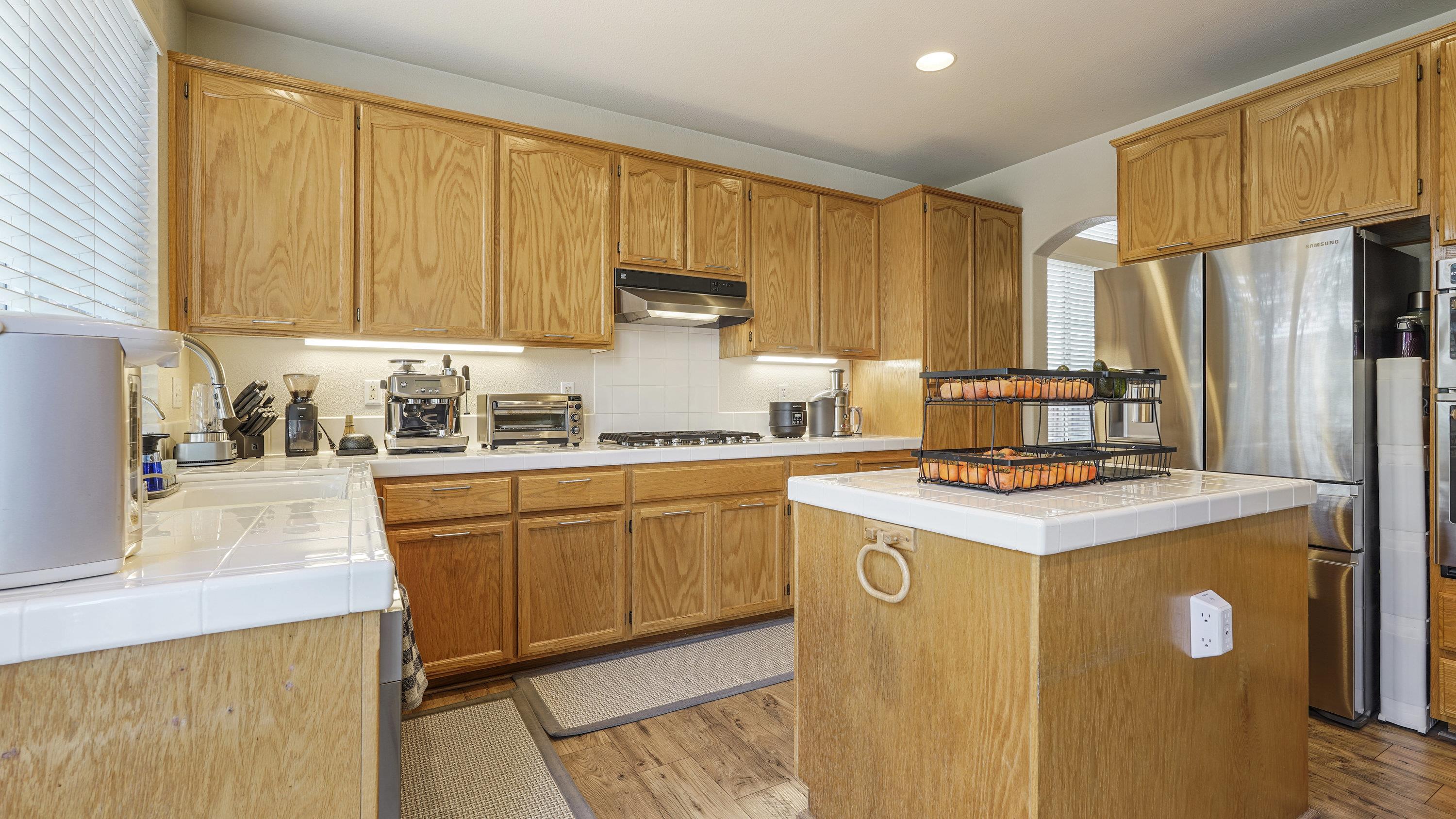 1388 Four Oaks Road San Jose, CA 95131 - Photo 12 of 47 a kitchen with stainless steel appliances granite countertop a stove a refrigerator a sink dishwasher and white cabinets with wooden floor