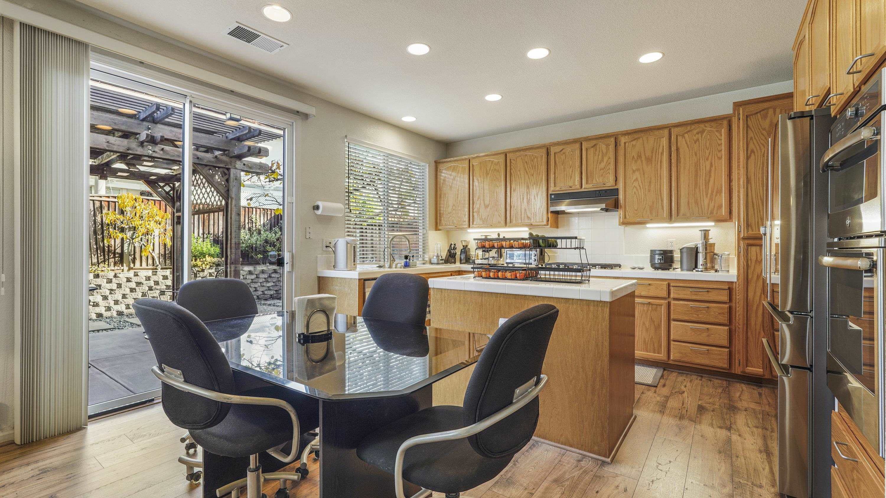 1388 Four Oaks Road San Jose, CA 95131 - Photo 15 of 47 a dining room with stainless steel appliances granite countertop a stove a refrigerator a table and chairs