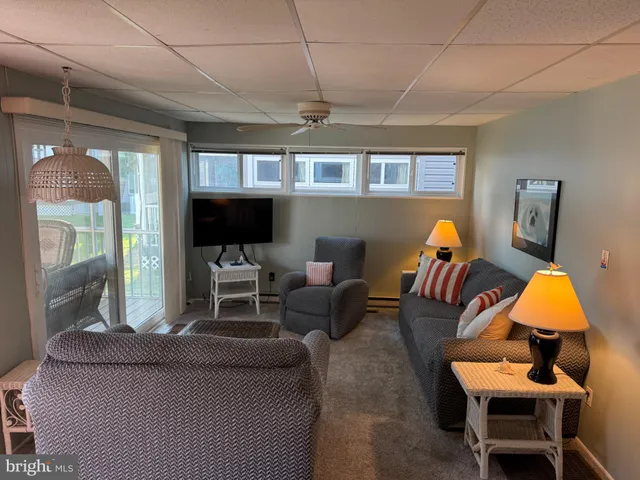a living room with furniture a ceiling fan and a window