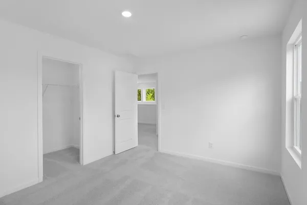 an empty room with windows and closet