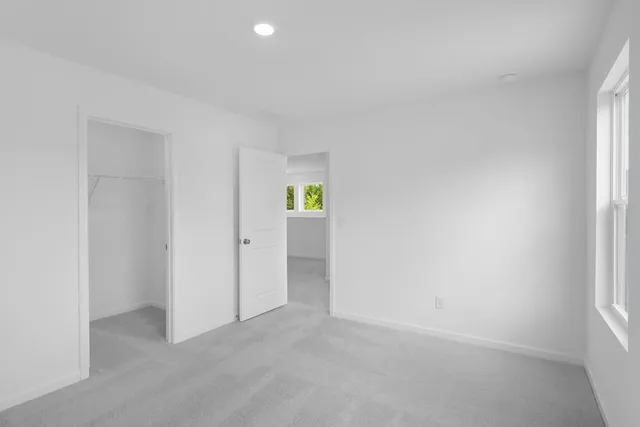 an empty room with windows and closet