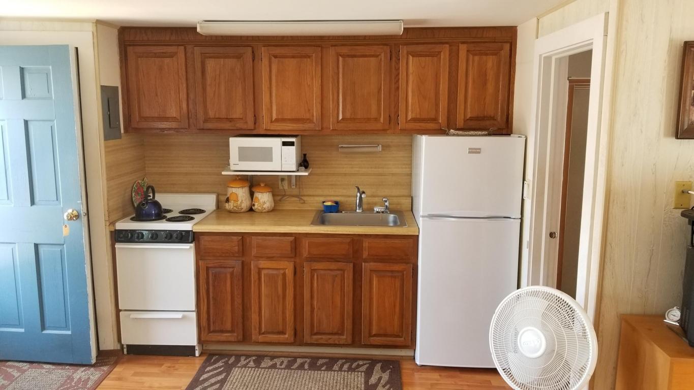174 Captain Chase Road, Unit 17 Dennis, MA 02639 - Photo 4 of 11 a kitchen with stainless steel appliances granite countertop a refrigerator a stove and a sink