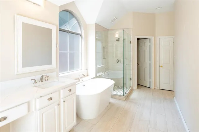 a spacious bathroom with a double vanity sink a mirror and a bathtub