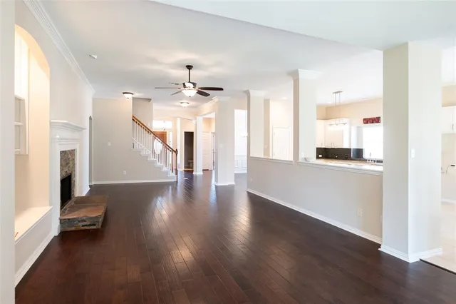 a view of a room with wooden floor fireplace and windows