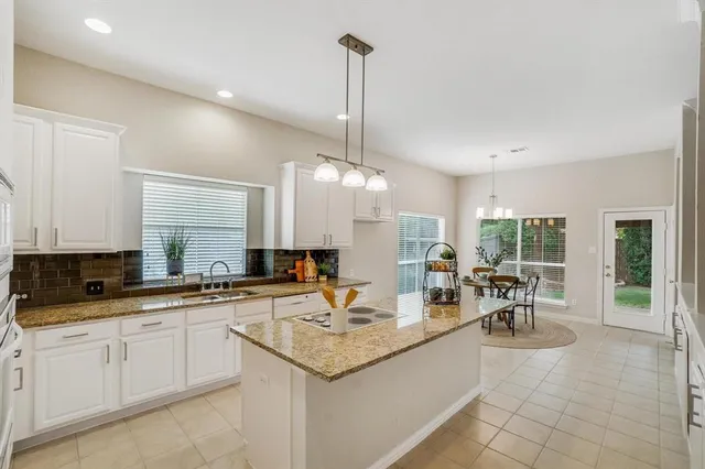 a kitchen with center island counter top space a sink appliances and a window