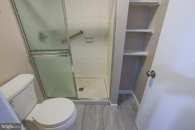 a white toilet sitting next to a shower