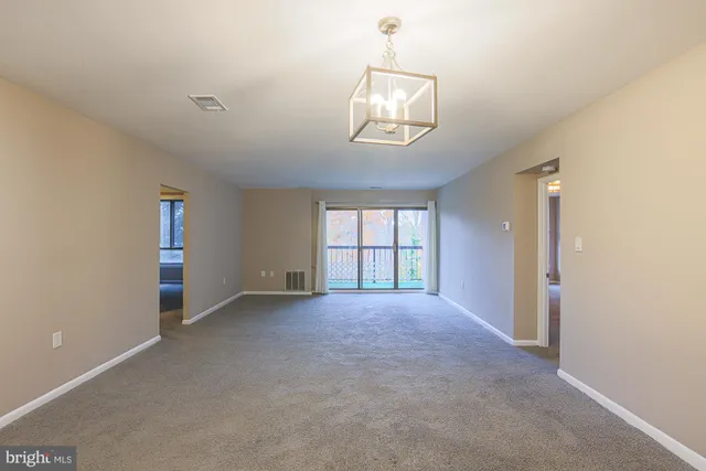 an empty room with windows and fireplace