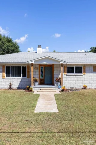 a front view of a house with a garden and yard