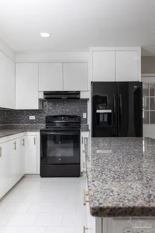 a kitchen with a refrigerator a stove top oven a sink dishwasher and white cabinets with wooden floor