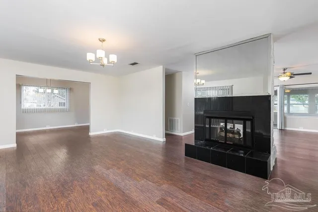 an empty room with wooden floor and fireplace
