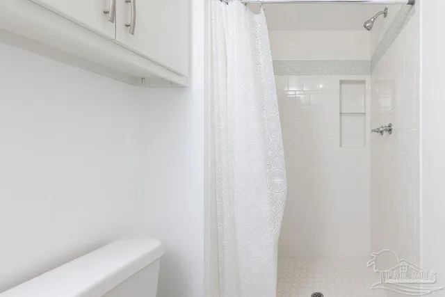 an empty room with wooden floor a ceiling fan and windows