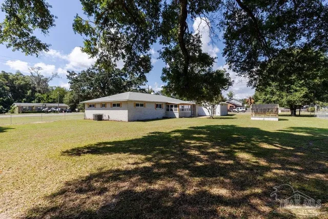 a view of a house with a yard and sitting area