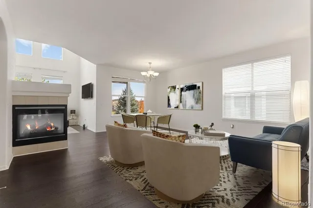 a living room with couches a flat screen tv and a fireplace