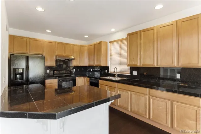 a kitchen with stainless steel appliances granite countertop a sink a stove and cabinets