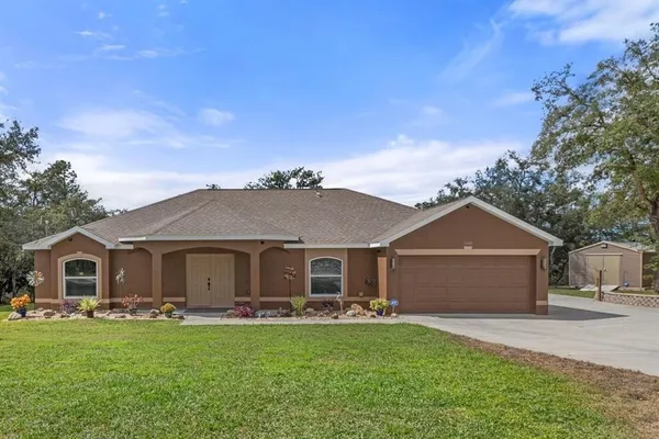 a front view of a house with yard and green space