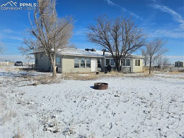 a view of large house with a yard covered in snow