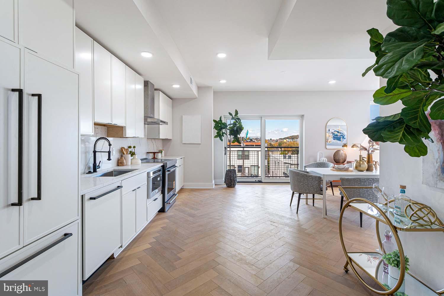 1516 East Capitol Street Northeast, Unit F Washington, DC 20003 - Photo 4 of 53 a kitchen with stainless steel appliances granite countertop a table chairs and a refrigerator