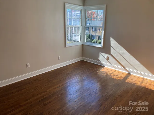 a view of a bedroom with wooden floor and cabinet