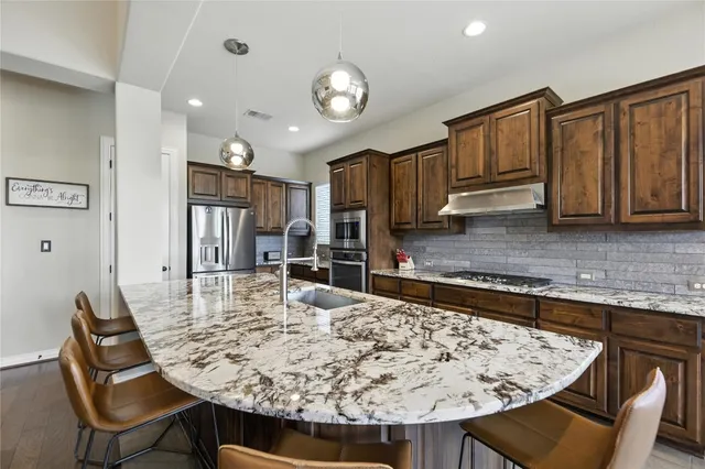 a kitchen with kitchen island a dining table and chairs