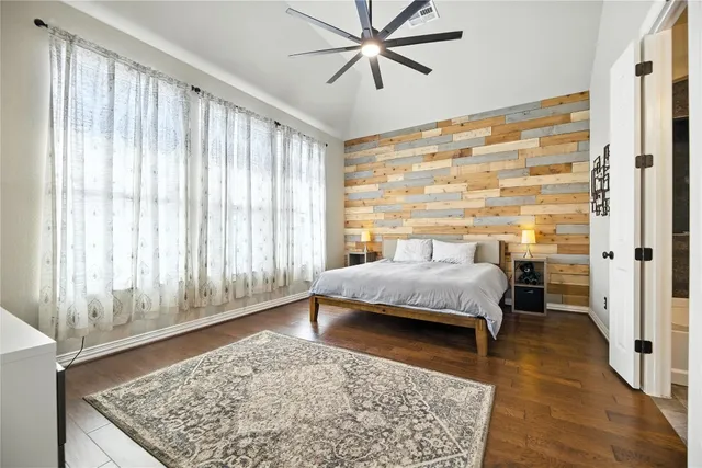 a bed sitting in a spacious bedroom next to a window