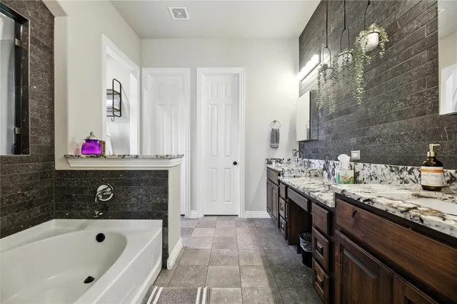 a bathroom with a tub sink and mirror