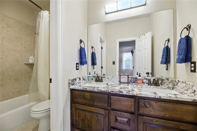 a bathroom with a granite countertop sink and a mirror a toilet