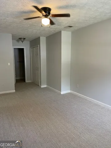 a view of an empty room and a ceiling fan
