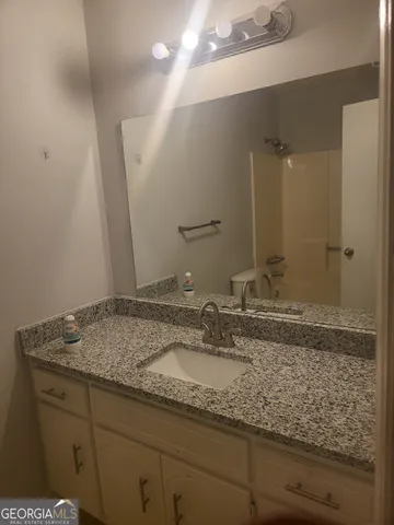 a bathroom with a granite countertop sink and a mirror