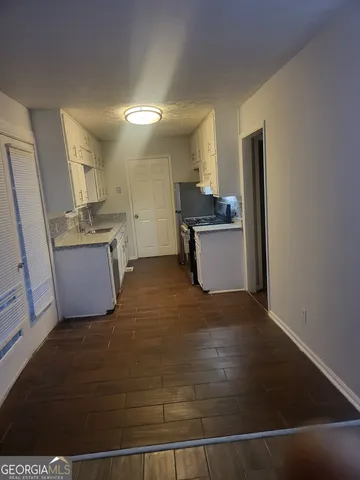 a kitchen with a sink cabinets and wooden floor