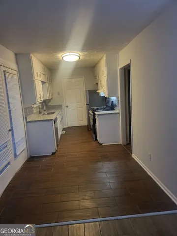 a kitchen with a sink cabinets and wooden floor